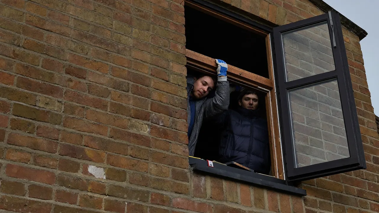 Two fitters working steadily on a window installation in a UK home