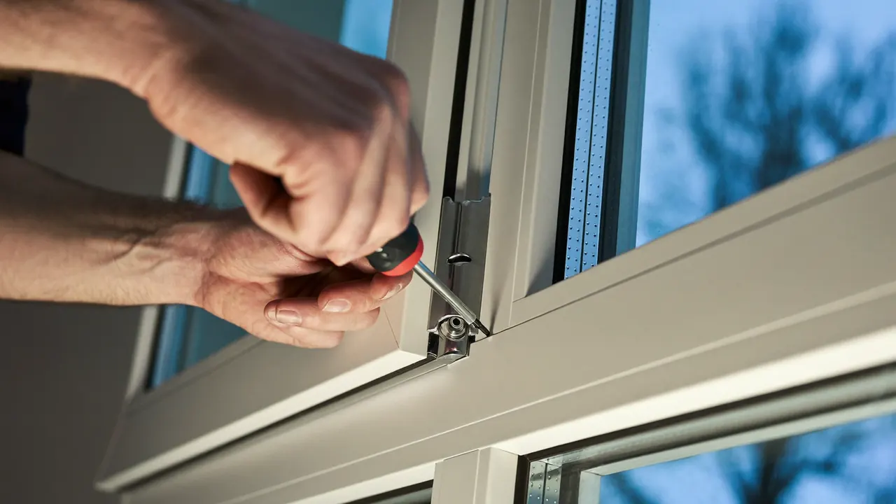 Installer adjusting a window hinge during an aftercare visit