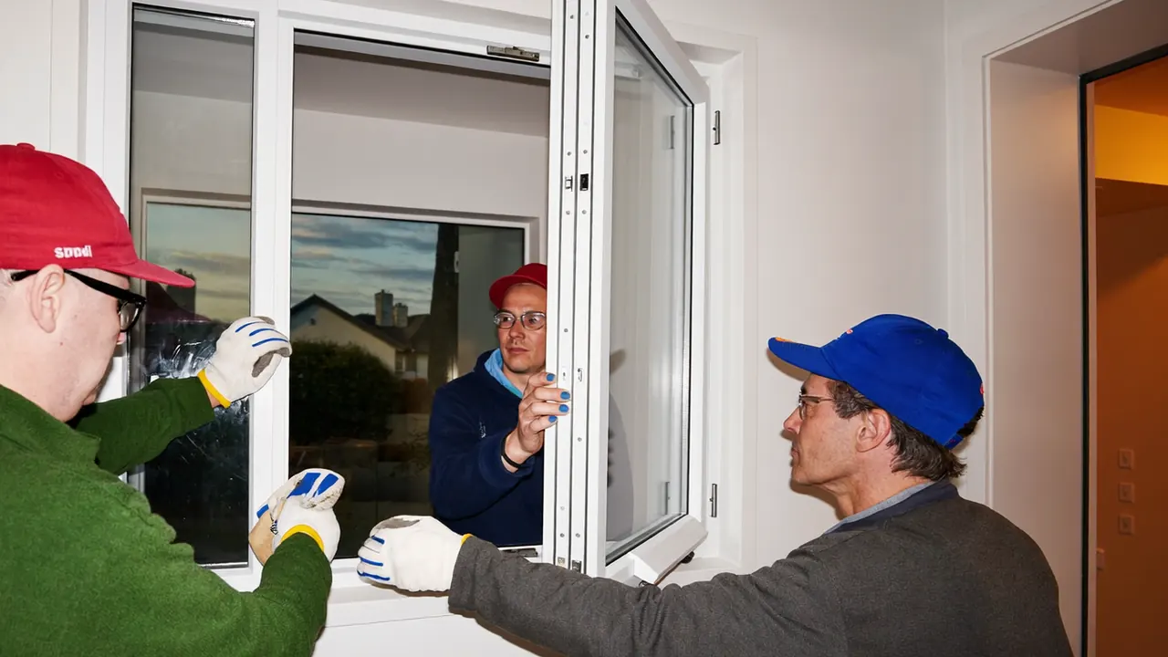 Installation team finishing off a window fit and tidying up at a home