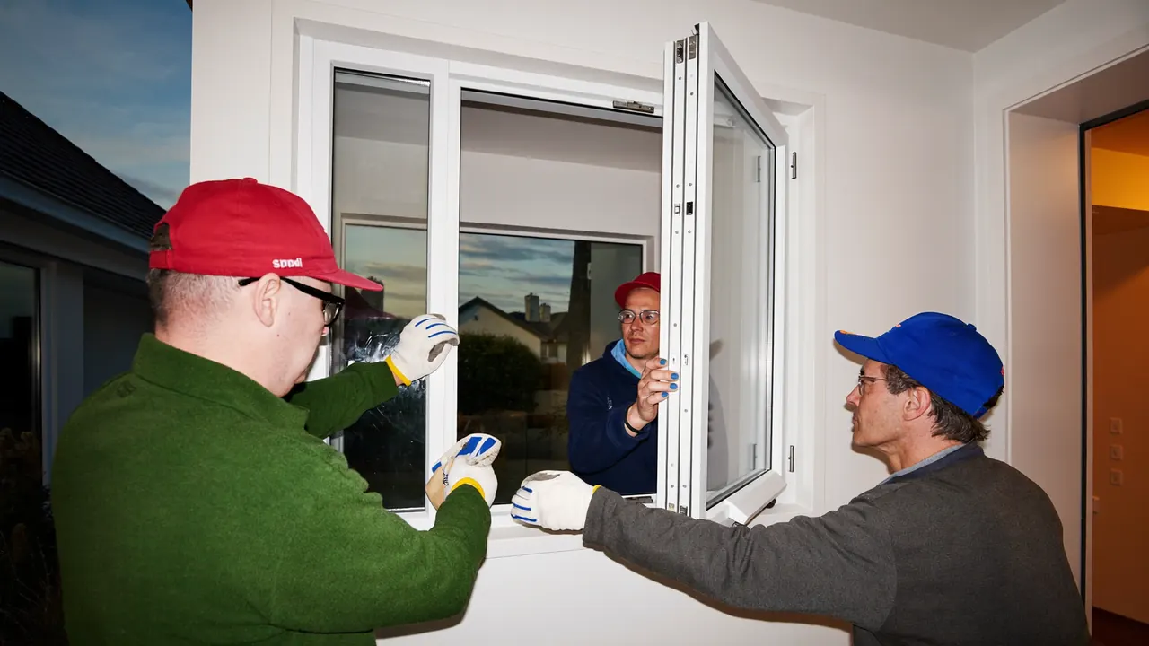 Installer lifting a new double glazed unit into a prepared window opening